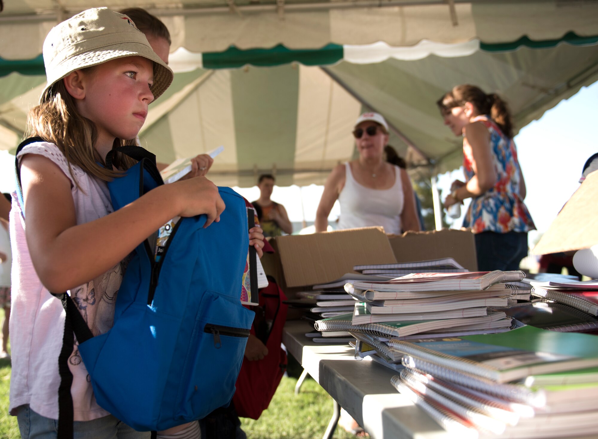A child picks out school supplies during the Back-To-School Bash July 25, 2018, at Luke Air Force Base, Ariz. The event allowed on-base and local organizations to provide hundreds of backpacks, notebooks, folders, pencils, and other school supplies to military families preparing for the new school year. (U.S. Air Force photo by Senior Airman Ridge Shan)