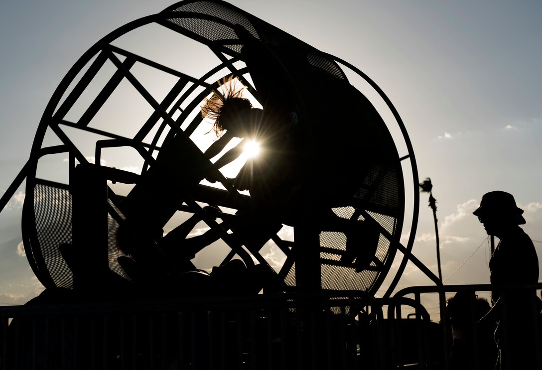 Two children are spun in a carnival ride at the Back-To-School Bash July 25, 2018, at Luke Air Force Base, Ariz. The Bash provided free school supplies, food, carnival rides, and other activities to military families. (U.S. Air Force photo by Senior Airman Ridge Shan)