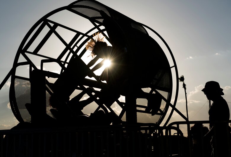 Two children are spun in a carnival ride at the Back-To-School Bash July 25, 2018, at Luke Air Force Base, Ariz. The Bash provided free school supplies, food, carnival rides, and other activities to military families. (U.S. Air Force photo by Senior Airman Ridge Shan)