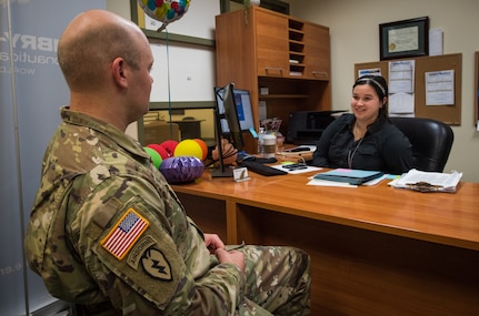 U.S. Army Staff Sgt. Mathew Kelly, assigned to the 1st Squadron (Airborne), 40th Cavalry Regiment, 4th Infantry Brigade Combat Team (Airborne), 25th Infantry Division, U.S. Army Alaska, speaks with Kara Hopkins, Embry-Riddle Aeronautical University associate campus director, at the education center at Joint Base Elmendorf-Richardson, Alaska, Aug. 8, 2018. Embry-Riddle is one of four colleges that offer undergraduate and graduate programs at the education center.