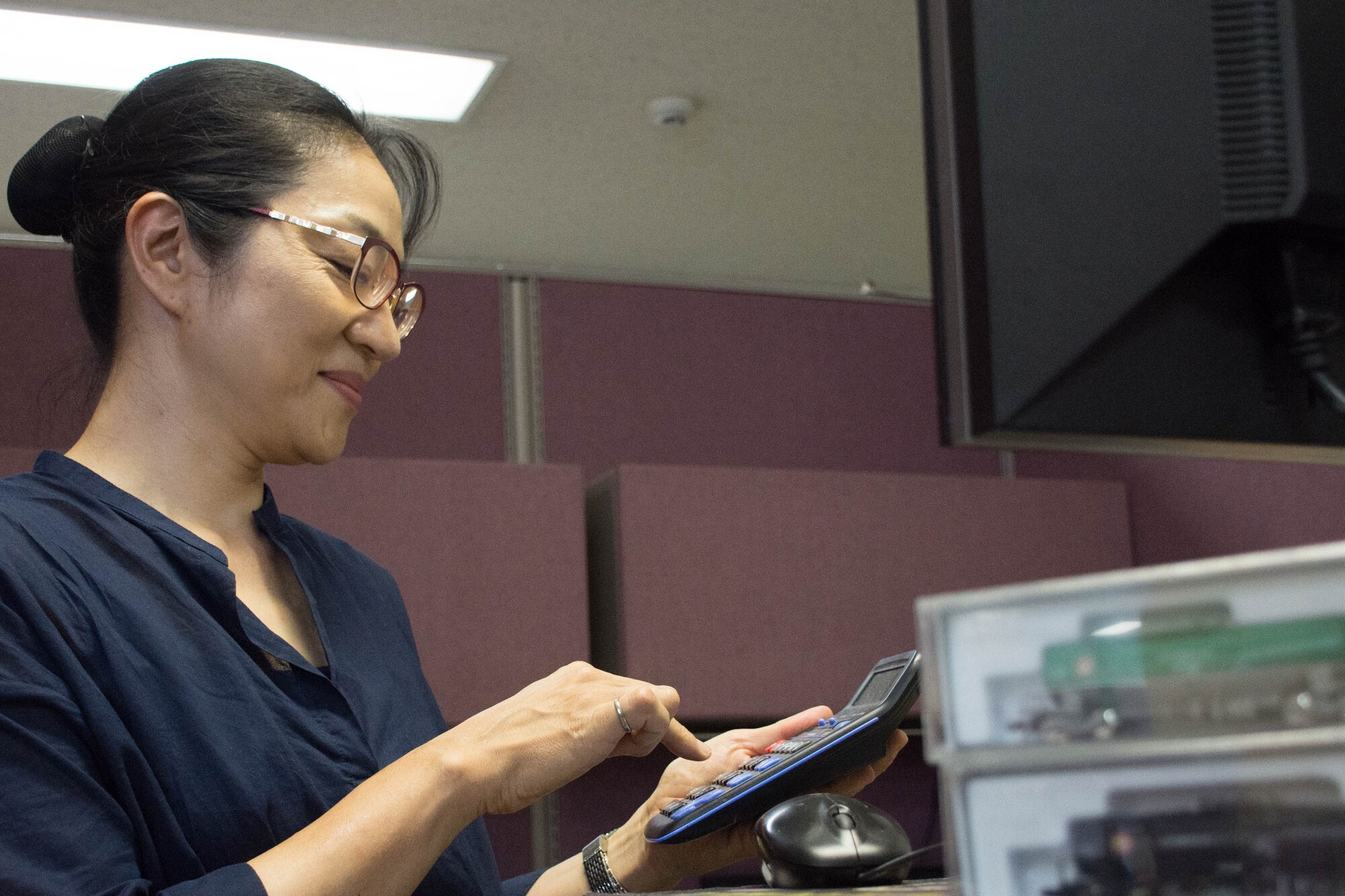 Maki Kodama, 374th Contracting Squadron team lead calculates costs, Aug. 2, 2018, Yokota Air Base, Japan.