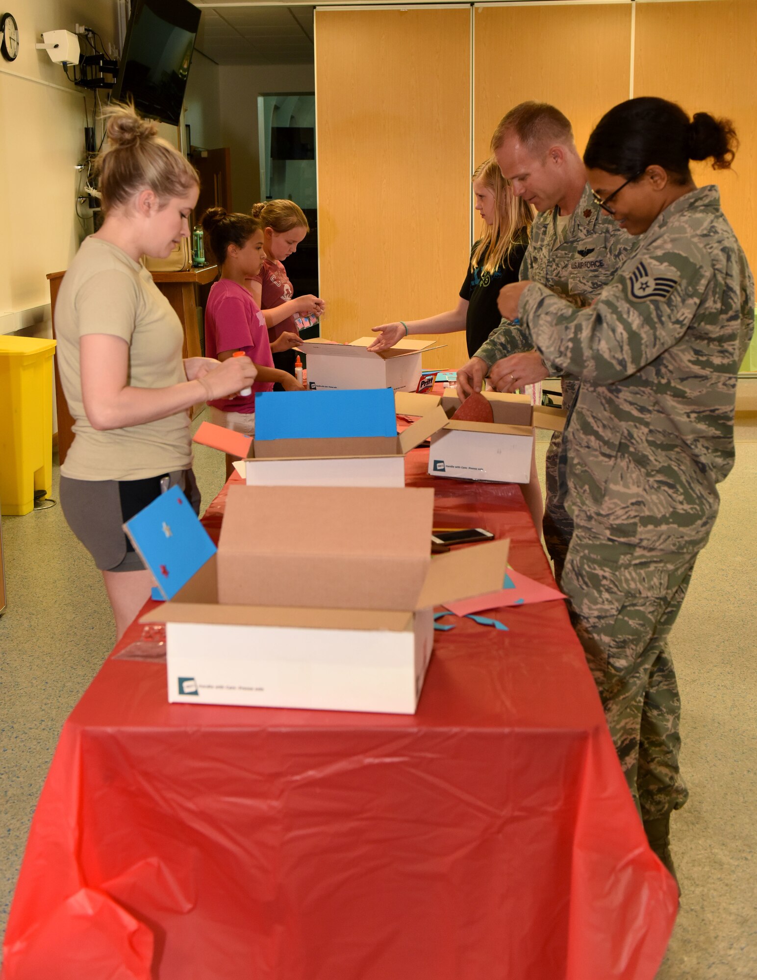 U.S. Airmen from the 100th Air Refueling Wing Wing Staff Agencies and other volunteers at RAF Mildenhall, England, decorate care packages for deployed personnel, July 24, 2018.  Once decorated, the care packages are filled with donated snacks and messages from family and friends. (US. Air Force photo by Senior Airman Lexie West)
