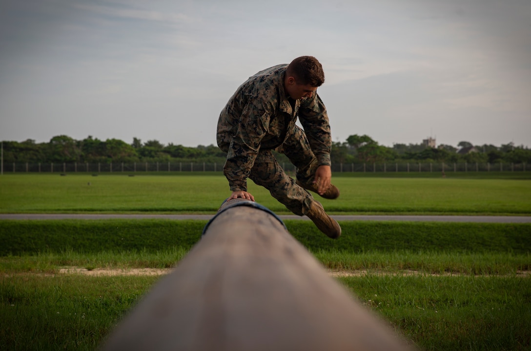 A Marine with Marine Wing Support Squadron 172, Marine Aircraft Group 36, 1st Marine Aircraft Wing, jumps over a log at Camp Hansen, Okinawa, Japan, August 3, 2018. The MWSS-172 Marines participated in the obstacle course together to boost morale and strengthen unit cohesion. The Marines utilize proper technique instead of muscling through the course to reduce risk of injury.