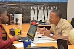 Navy Petty Officer 2nd Class Kristofer D. Wilson, a ship serviceman and recruiter assigned to Navy Recruiting District Los Angeles, speaks to a potential applicant at a recruiting station in Inglewood, Calif., July 18, 2018. Navy photo by Petty Officer 1st Class Richard Perez