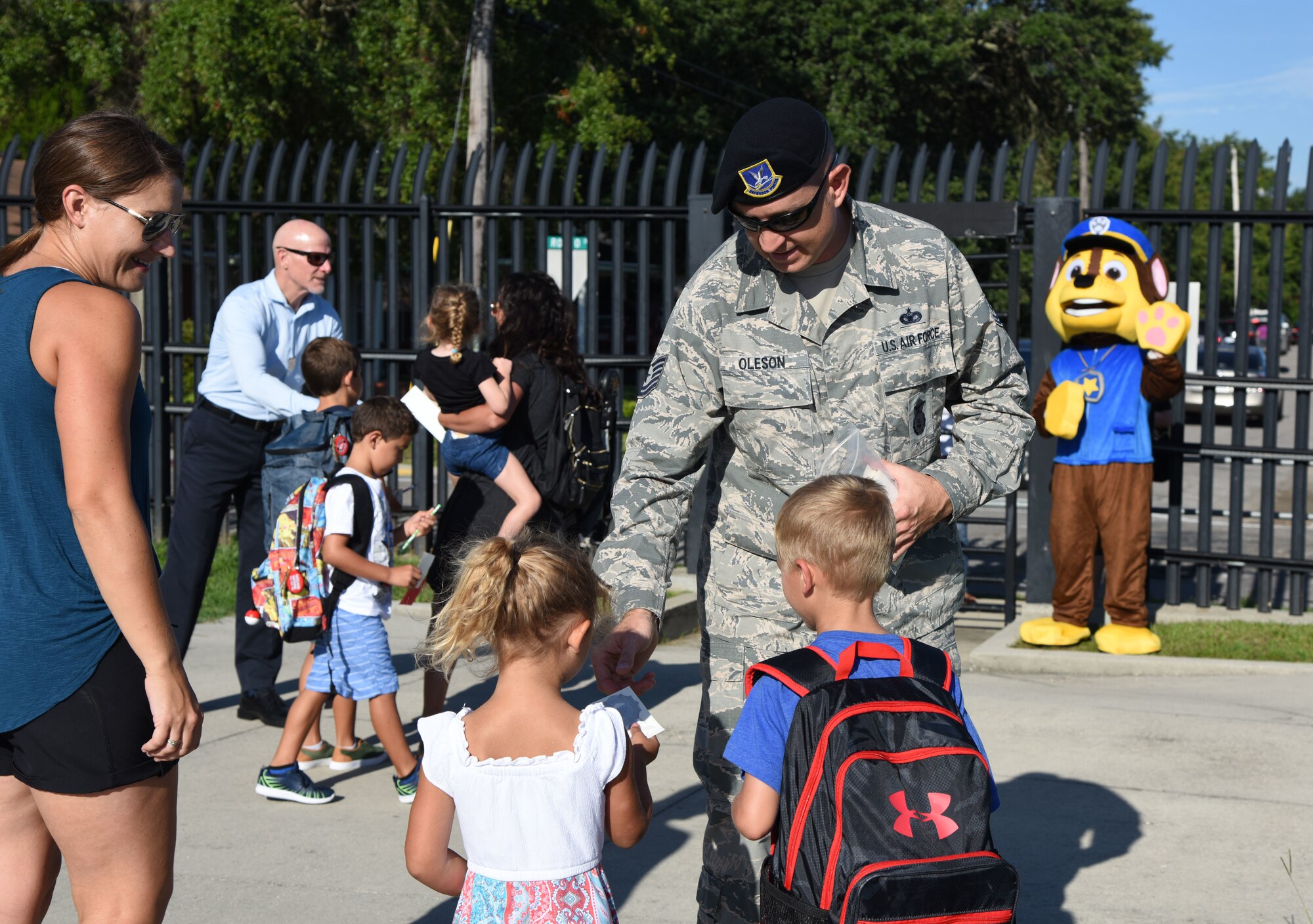 Tech. Sgt. Matthew Oleson, 81st Security Forces Squadron operations NCO in charge, passes out stickers to Keesler children on Keesler Air Force Base, Mississippi, Aug. 6, 2018. Keesler children were greeted by members from the 81st SFS, Keesler Fire Department and 81st Force Support Squadron as they went to Jeff Davis Elementary School on the first day of school. (U.S. Air Force photo by Kemberly Groue)