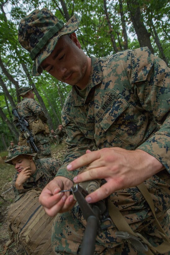 U.S. Marine Corps Cpl. Chris Moore, a combat engineer, attached to Kilo Company, 3rd Battalion, 25th Marine Regiment, attaches a target point illuminator to his rifle before beginning a land navigation course during Exercise Northern Strike at Camp Grayling, Mich., Aug. 6, 2018.