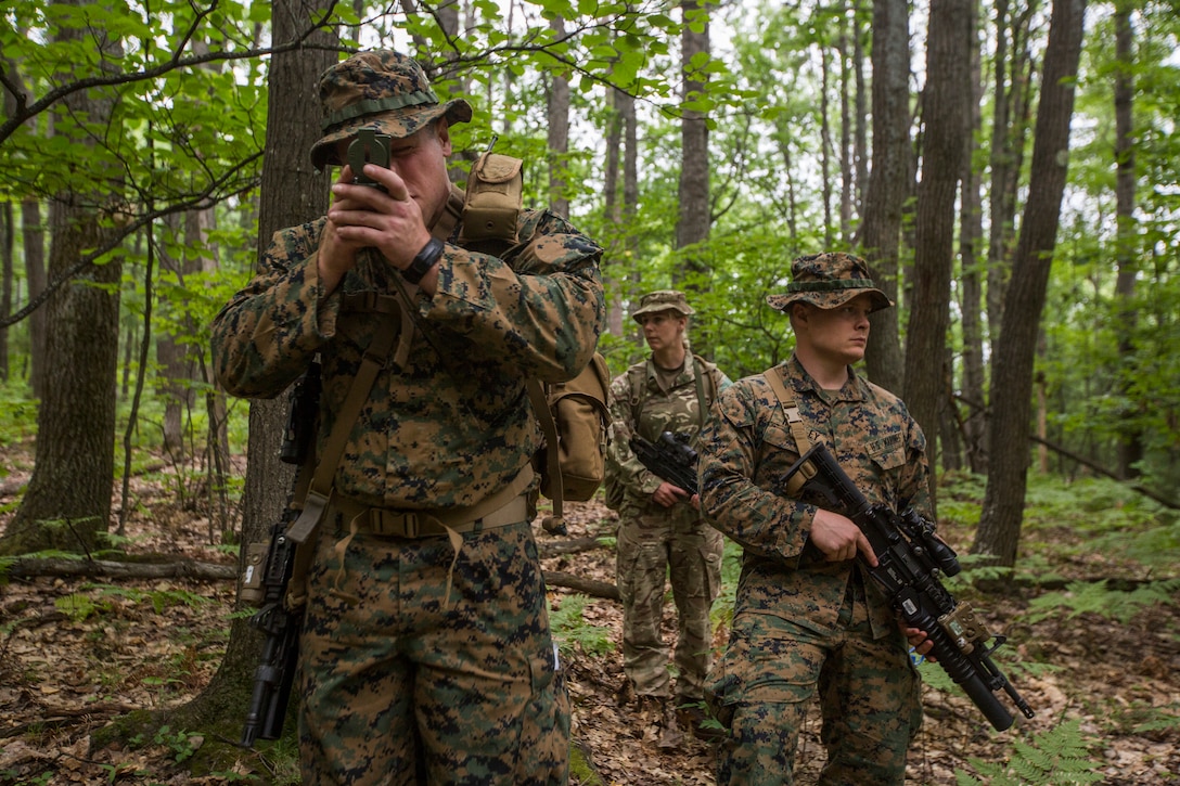 British Pvt. Adele Frost (center), a medic with 3rd Princess of Wales Royal Regiment, and U.S. Marine Corps Sgt. Jacob Mueller (left) and Sgt. Jordan Hensley (left) squad leaders with Kilo Company 3rd Battalion, 25th Marine Regiment, participate in a land navigation course at Exercise Northern Strike in Camp Grayling, Mich., Aug. 6, 2018.