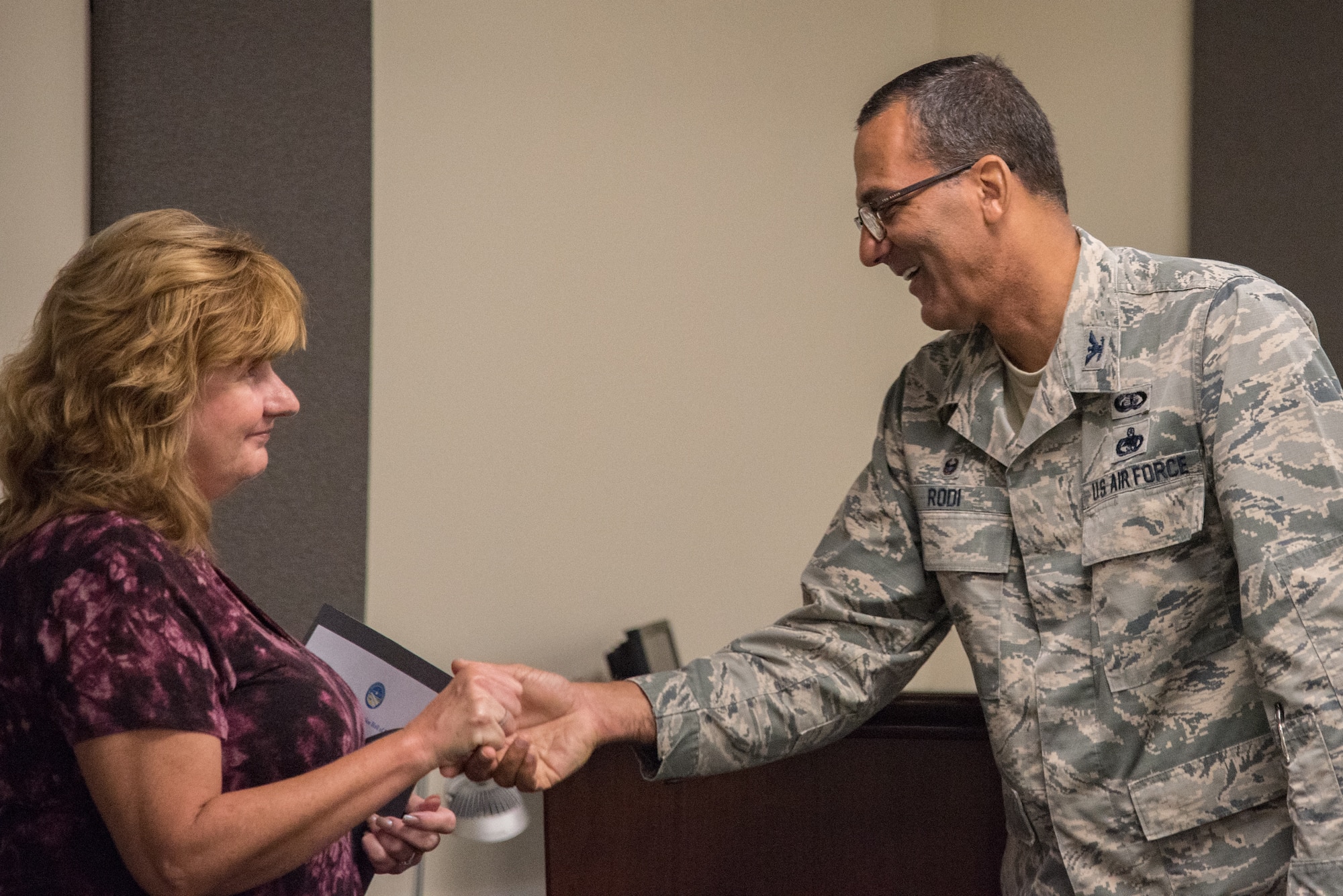 On behalf of the 512th Airlift Wing commander, Col. Arthur Rodi, 512th Mission Support Group commander, coins retired Senior Master Sgt. Kathleen Lambert, a former 512th AW loadmaster, during a Delaware Aviation Hall of Fame inductee notification at Dover Air Force Base Del., Aug. 3, 2018. Lambert's official induction is scheduled to take place at the Delaware Aviation Hall of Fame Honors Banquet Nov. 3, 2018.  (U.S. Air Force photo by Staff Sgt. Damien Taylor)