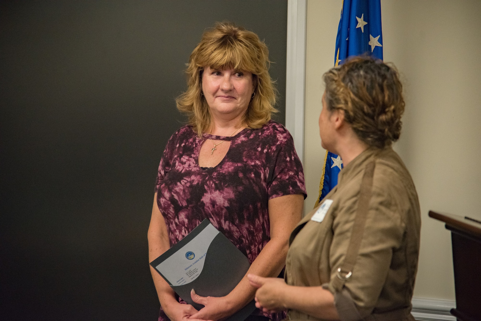 Rachel Anderson, a Delaware Aviation Hall of Fame trustee, right, speaks to retired Senior Master Sgt. Kathleen Lambert, a former 512th Airlift Wing loadmaster, left, during a Delaware Aviation Hall of Fame inductee notification at Dover Air Force Base, Del., Aug. 3, 2018. Anderson traveled to Dover AFB to deliver Lambert's official inductee letter. (U.S. Air Force photo by Staff Sgt. Damien Taylor)