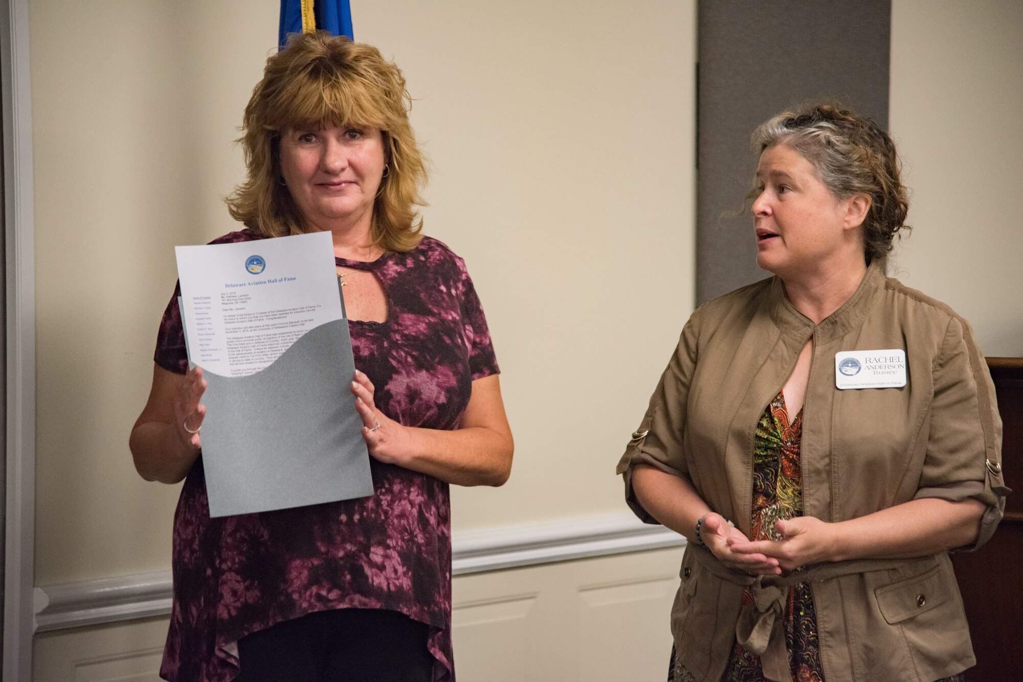 Rachel Anderson, a Delaware Aviation Hall of Fame trustee, right, speaks to retired Senior Master Sgt. Kathleen Lambert, a former 512th Airlift Wing loadmaster, left, during a Delaware Aviation Hall of Fame inductee notification at Dover Air Force Base, Del., Aug. 3, 2018. The Delaware Aviation Hall of Fame selected Lambert as an honoree for her accomplishments as a 512th AW flyer. (U.S. Air Force photo by Staff Sgt. Damien Taylor)