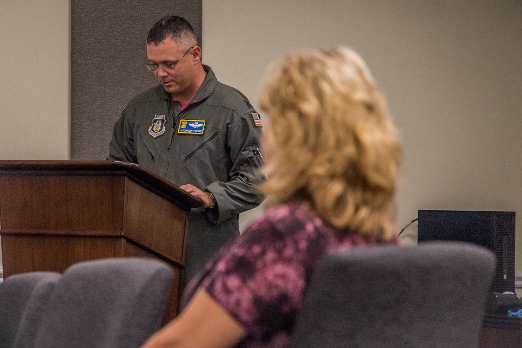 Lt. Col. Jason Pennypacker, left, 512th Operations Group deputy commander, speaks during a Delaware Aviation Hall of Fame inductee notification for retired Senior Master Sgt. Kathleen Lambert, a former 512th Airlift Wing loadmaster, right, at Dover Air Force Base, Del., Aug. 3, 2018. Pennypacker read Lambert's career highlights, which fit the criteria for selection into the Delaware Aviation Hall of Fame. (U.S. Air Force photo by Staff Sgt. Damien Taylor)