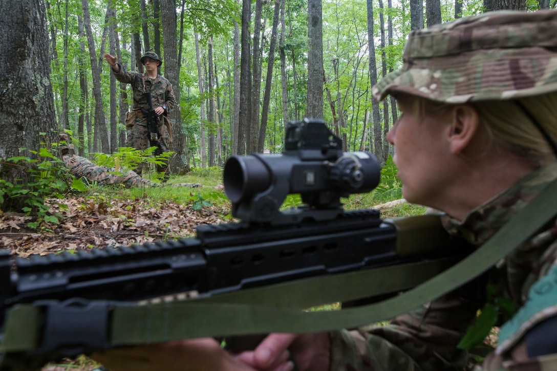 British Pvt. Adele Frost, a medic with 3rd Princess of Wales Royal Regiment, goes over Marine Corps fire and maneuver drills with U.S. Marines from Kilo Company, 3rd Battalion, 25th Marine Regiment, during Exercise Northern Strike at Camp Grayling, Mich., Aug. 6, 2018.
