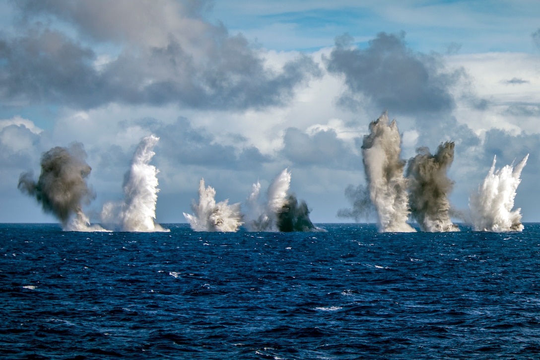 Aircraft create a  “Wall of Water” display during an ordnance drop in the ocean.