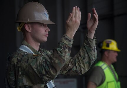 U.S. Army Spc. Blake Patterson, 149th Seaport Operations Company, 10th Transportation Battalion, 7th Transportation Brigade, directs vehicles onto a vessel during Exercise Dragon Lifeline July 31, 2018, at the Federal Law Enforcement Training Center in Charleston, S.C.  The 841st Transportation Battalion hosted the exercise, facilitating training for Soldiers assigned to Fort Bragg, N.C., and Fort Eustis, Va. The exercise was designed to train participants in the planning and processes of rail, convoy, port and vessel operations.