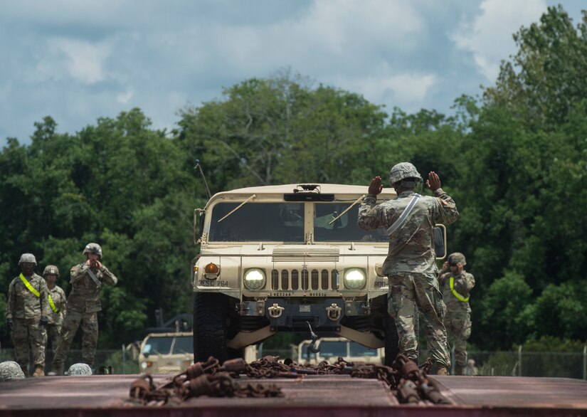 U.S. Army Soldiers guide a Humvee driver during rail operations as part of Exercise Dragon Lifeline July 31, 2018, at Joint Base Charleston’s Naval Weapons Station, S.C. The 841st Transportation Battalion hosted the exercise, facilitating training for Soldiers assigned to Fort Bragg, N.C., and Fort Eustis, Va. The exercise was designed to train participants in the planning and processes of rail, convoy, port and vessel operations.
