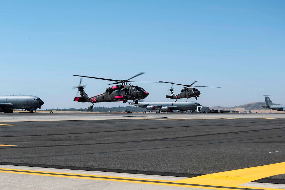 Two UH-60 Black Hawk helicopters land at Fairchild Air Force Base.