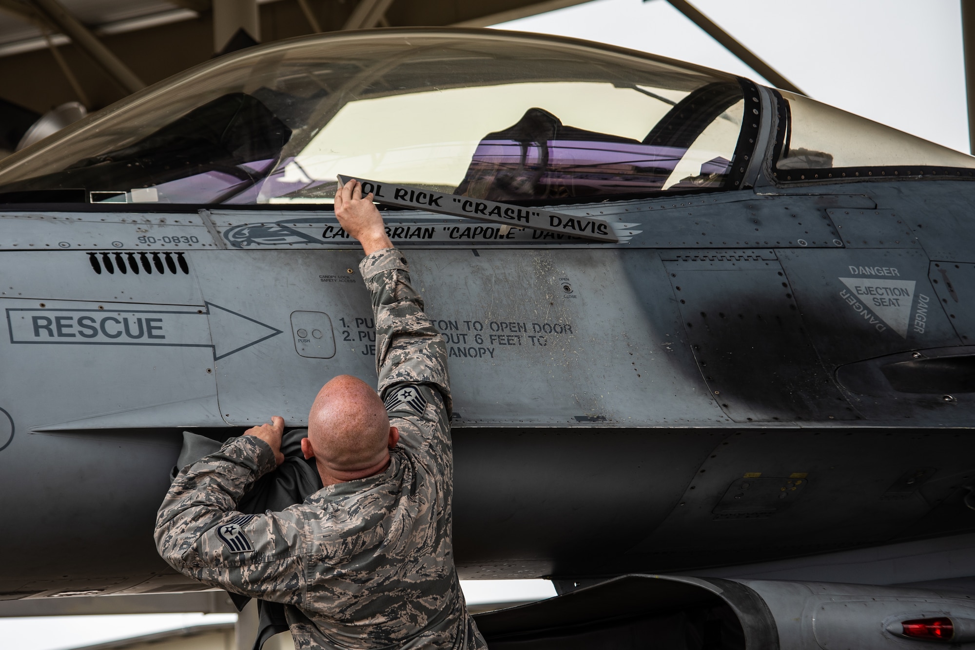U.S. Air Force Staff Sgt. Tyler Roecker, 20th Aircraft Maintenance Squadron dedicated crew chief, unveils 55th Fighter Squadron (FS) pilot Capt. Brian Davis’ name on an F-16CM Fighting Falcon at Shaw Air Force Base, S.C., Aug. 3, 2018.