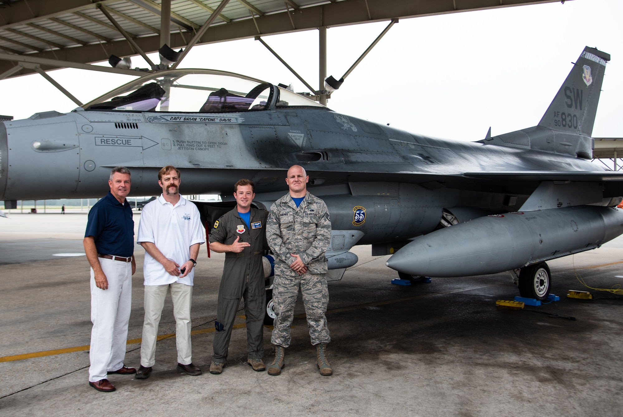 (From left) Retired U.S. Air Force Col. Rick Davis, former F-16 pilot, retired Senior Master Sgt. Daniel Henderson, former dedicated crew chief, Capt. Brian Davis, 55th Fighter Squadron F-16 pilot, and Staff Sgt. Tyler Roecker, 20th Aircraft Maintenance Squadron dedicated crew chief, stand on the flight line at Shaw Air Force Base, S.C., Aug 3, 2018.