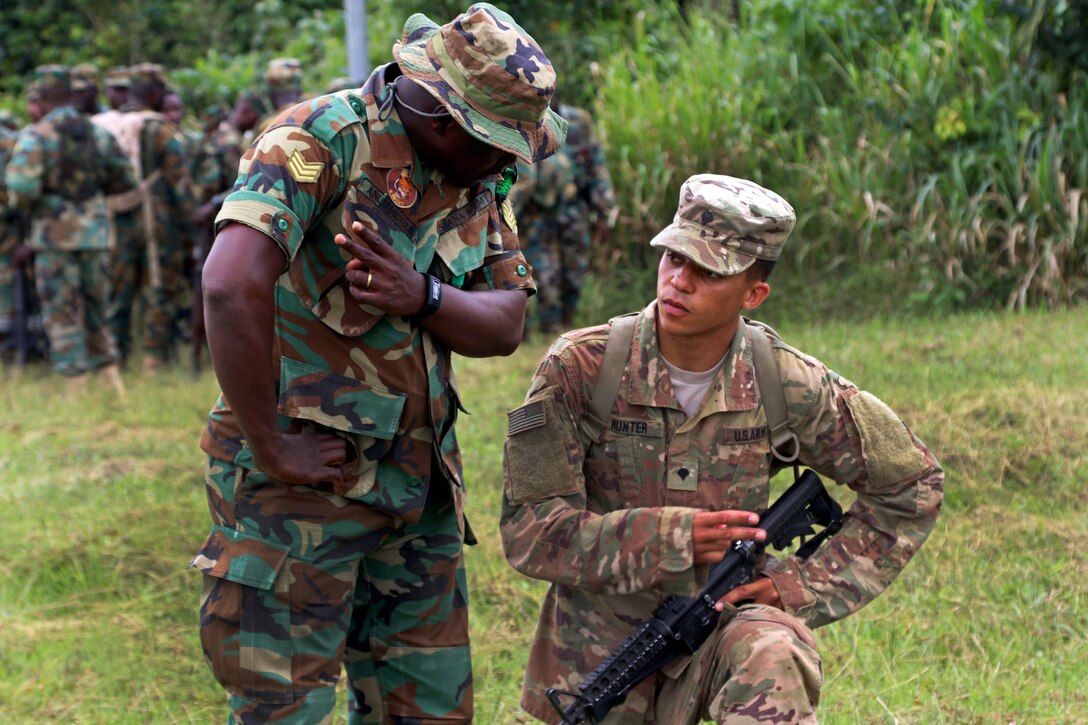 A U.S. soldier receive instructions from a Ghana soldier.