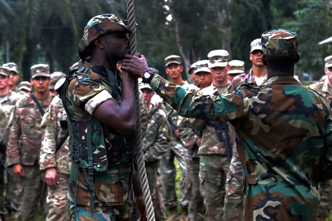 U.S. soldiers receive instructions from Ghana soldiers.
