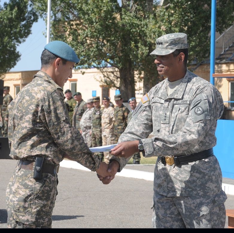 Lt. Gen. Vincent K. Brooks, Third Army/ARCENT commanding general, presents a soldier of the Kazakhstan Armed Forces with an award for his outstanding work in exercise Steppe Eagle 12 during closing ceremonies at Camp Illisky Training Center Sept. 20.