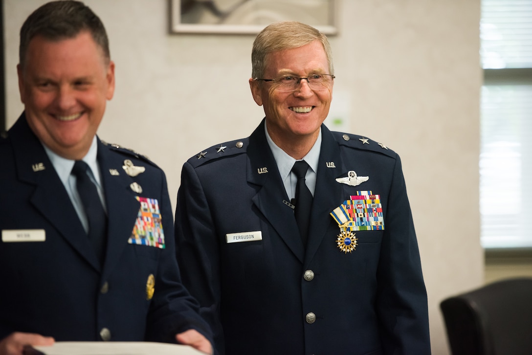 Maj. Gen. Gregory L. Ferguson (right), Air National Guard assistant to the commander, Air Force Special Operations Command (AFSOC), Hurlburt Field, Florida, smiles at the crowd alongside Lt. Gen. Marshall B. Webb, AFSOC commander, during Ferguson's retirement ceremony at Will Rogers Air National Guard Base in Oklahoma City, Aug. 4, 2018.