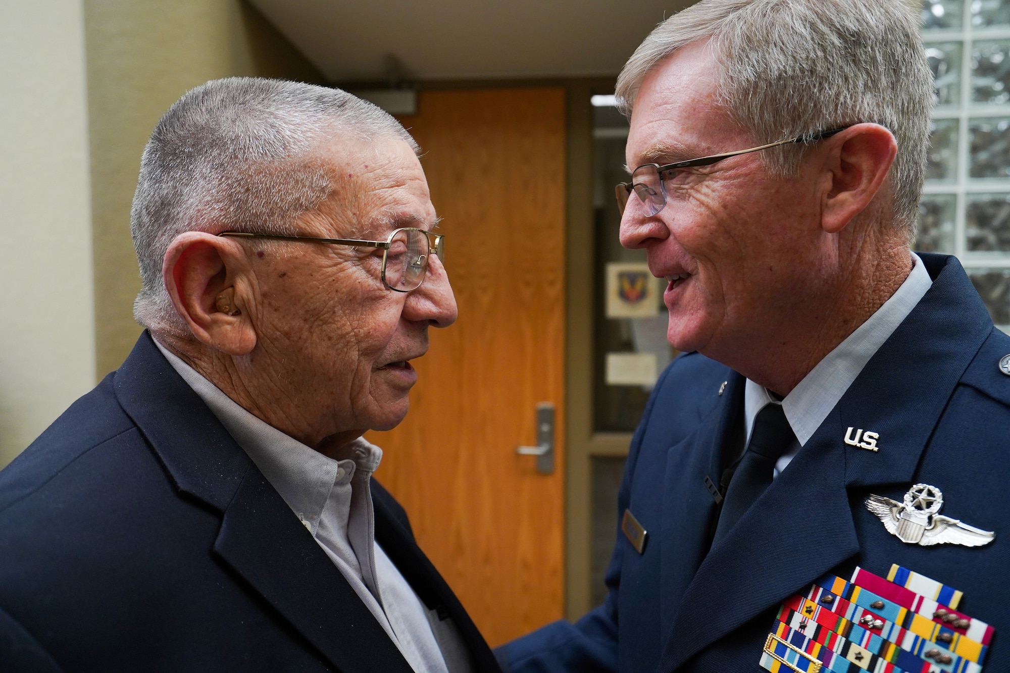 Maj. Gen. Gregory L. Ferguson (right), former and 14th wing commander of the now 137th Special Operations Wing, Will Rogers Air National Guard Base in Oklahoma City, greets retired Maj. Gen. Stanley F.H. Newman, the fourth 137th wing commander, before Ferguson's retirement ceremony at Will Rogers Air National Guard Base, Aug. 4, 2018.