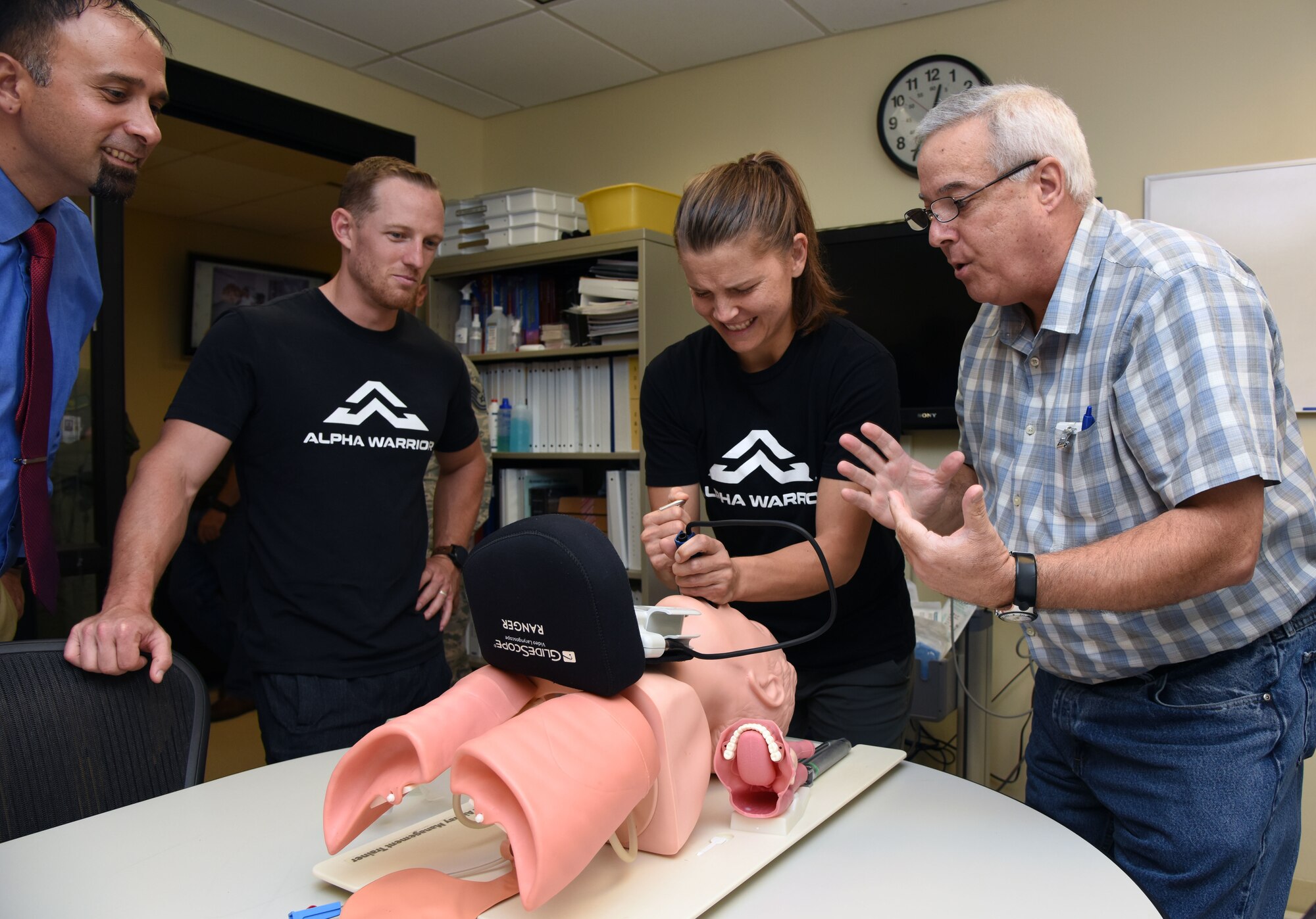 Randy Bernhardt, 81st Medical Group medical simulation coordinator, guides Sara Heesen, Alpha Warrior professional athlete, with inserting an endotracheal tube on a "patient" at the Keesler Medical Center on Keesler Air Force Base, Mississippi, Aug. 2, 2018. The 81st Force Support Squadron and the Air Force Services Activity hosted the Alpha Warriors during a two-day visit which consisted of a tour of the base and an Alpha Warrior battle rig competition in order to promote comprehensive airman fitness. (U.S. Air Force photo by Kemberly Groue)