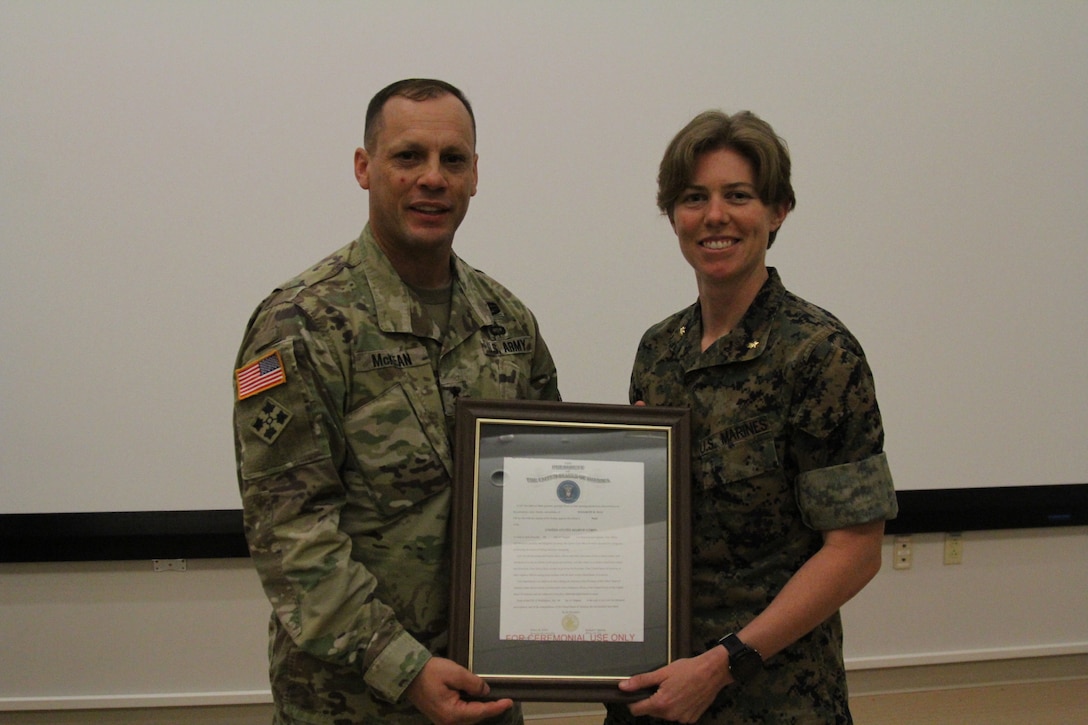 USAG CAMP HUMPHREYS, Korea – Maj. Gen. Scott McKean (left), commander of 2nd Infantry Division, Combined Republic of Korea, U.S. Division, and Maj. Elizabeth M. Hall (right),  U.S. Marine Corps Forces Korea G3 Logistics Plans officer In charge, display her promotion warrant following her promotion ceremony here, Aug 6.  Hall, a native of Erie, Pa., previously served with U.S. Marine Corps Special Operations Command, Training and Education Command, and deployed in support of Operation Enduring Freedom.  (U.S. Marine Corps photo by Sgt. Nathaniel Hanscom/Released)