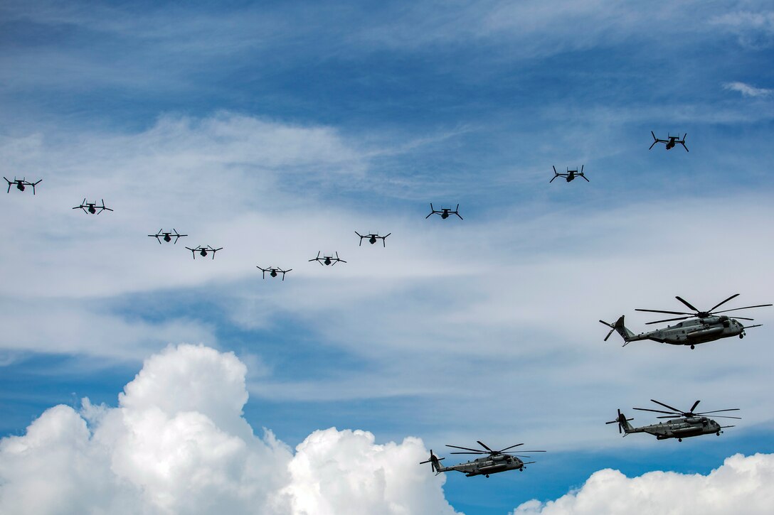 Aircraft fly in a blue sky with clouds.