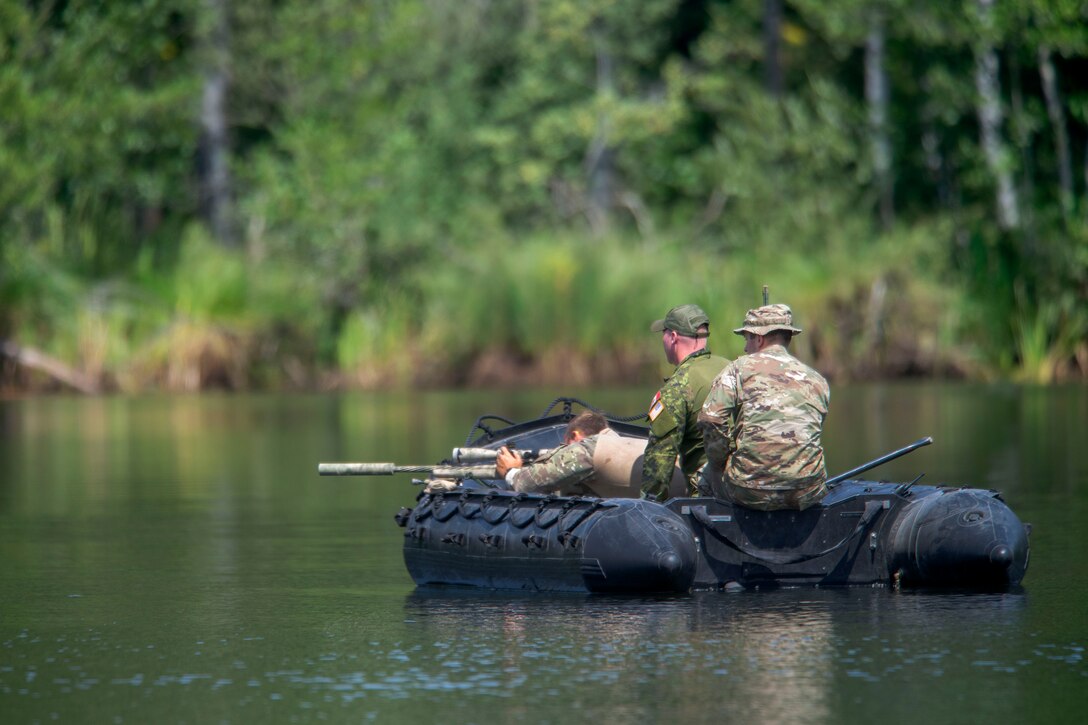 A U.S. sniper fires his weapon from a combat rubber raiding craft at targets placed across a lake.
