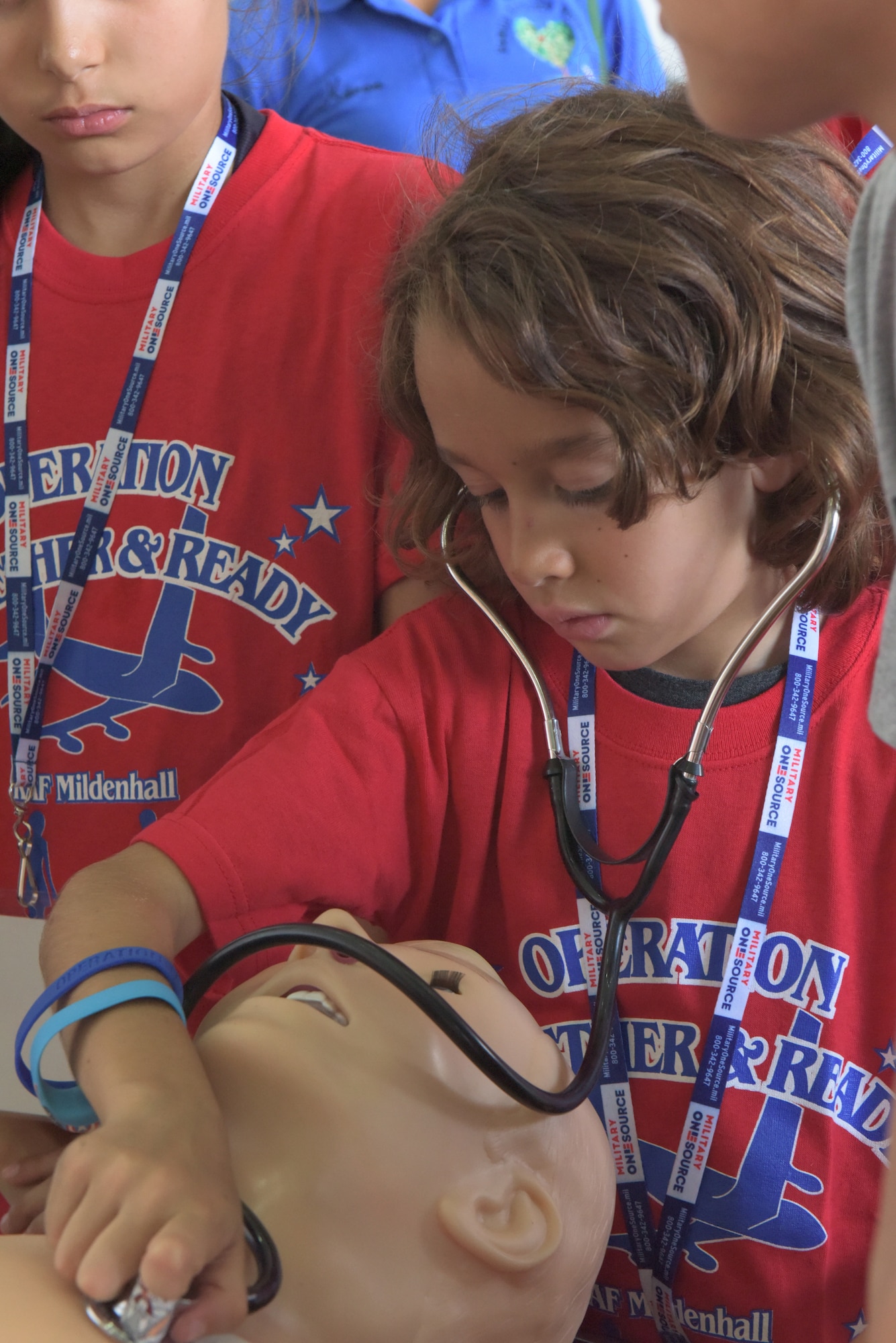 A boy wears a stethoscope while learning how to listen to a heartbeat at RAF Mildenhall, England, Aug. 3, 2018. Self-aid and buddy care was one of the stations featured at the “kids deployment line.” (U.S. Air Force photo by Senior Airman Kelly O’Connor)