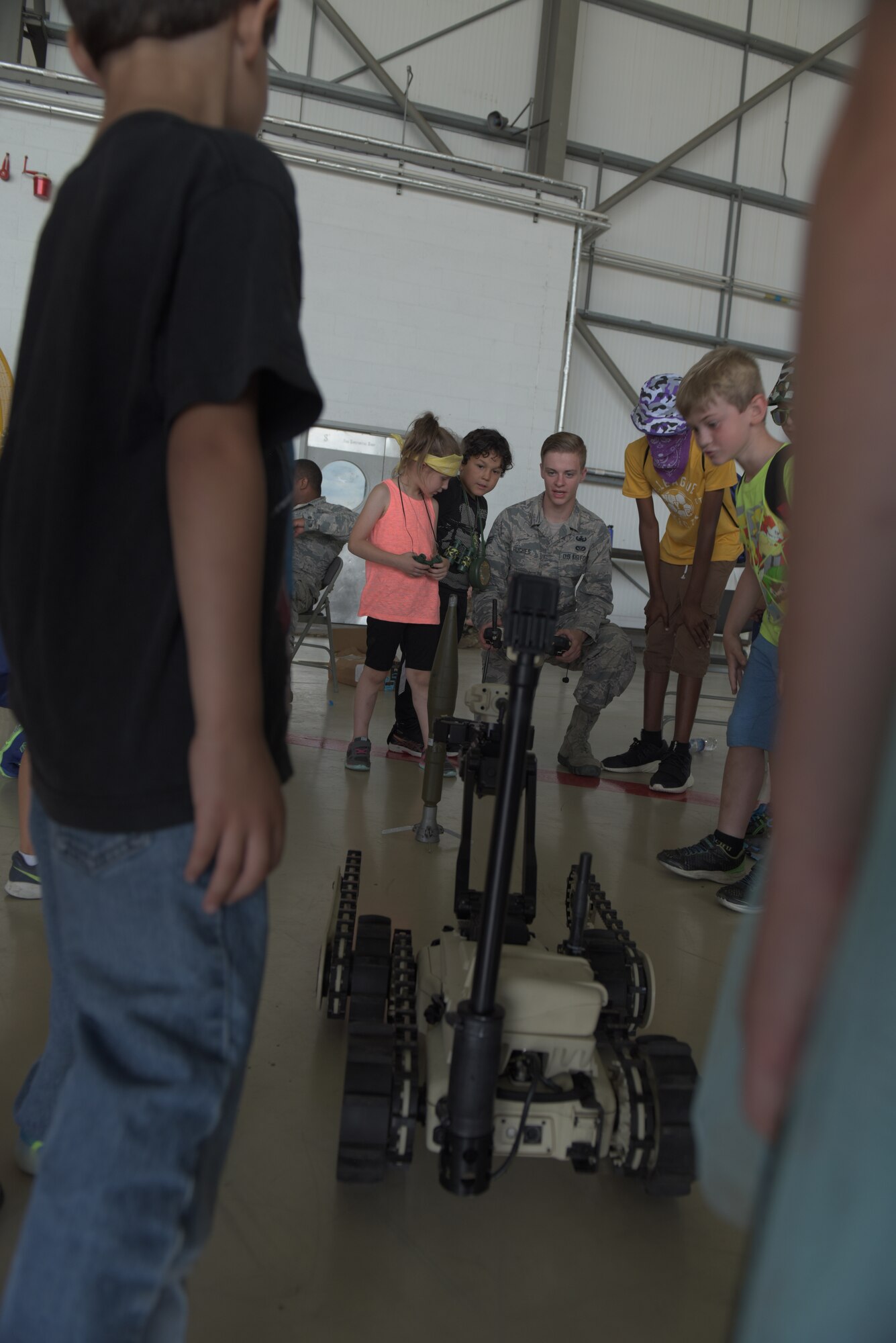An Airman from the 48th Fighter Wing’s Explosive Ordnance Disposal operates a robot as children look on at RAF Mildenhall, England, Aug. 3, 2018. EOD was one of 22 agencies who participated in the event to teach kids what life is like while deployed. (U.S. Air Force photo by Senior Airman Kelly O’Connor)
