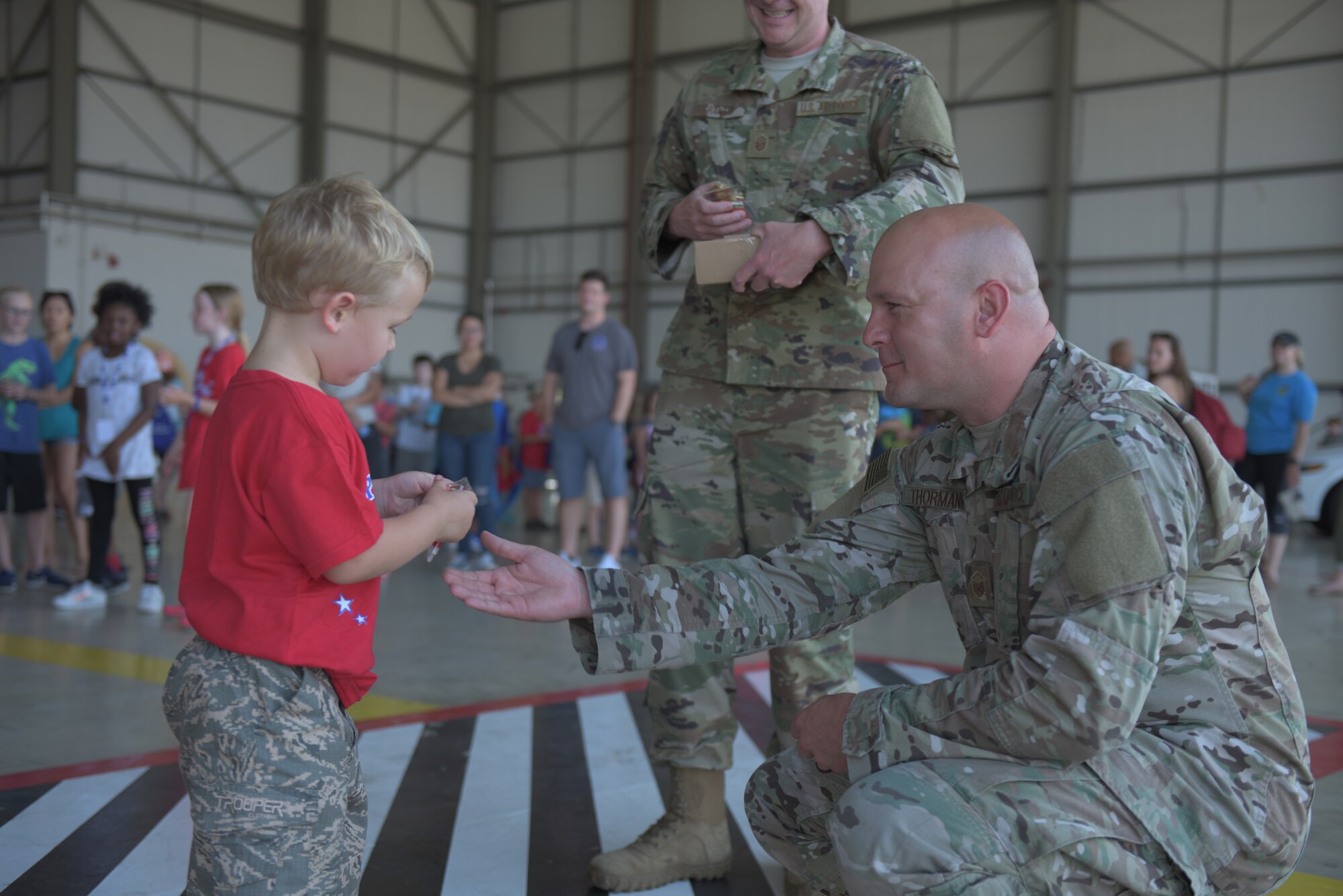 A boy looks at the coin he received from his commander after completion of the “kids deployment line” at RAF Mildenhall, England, Aug. 3, 2018. The Airman and Family Readiness Center hosted the event for the second year in a row to teach kids about what life is like during a deployment. (U.S. Air Force photo by Senior Airman Kelly O’Connor)