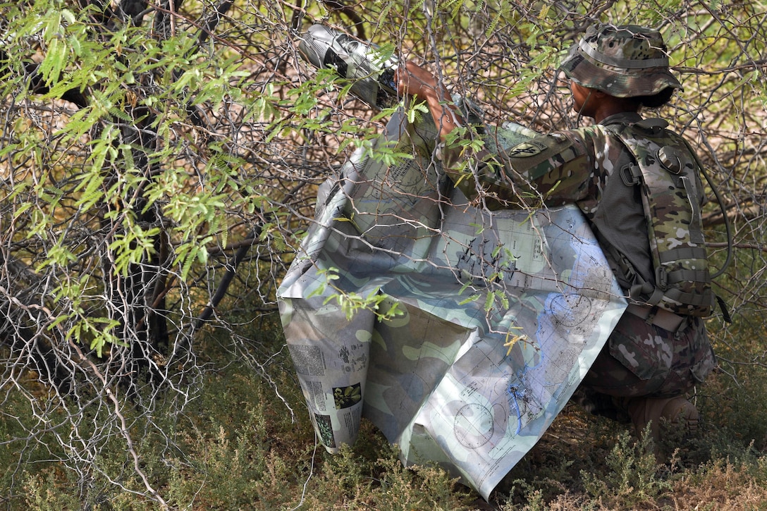 A soldier surveys a map during SERE training.