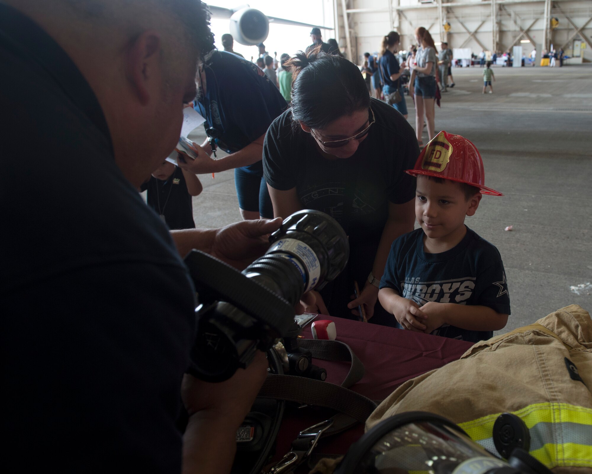 Braden Pewo, son of Blake Pewo, a C-17 aircrew chief at the 97th Maintenance Group, observes the capabilities of a fire hydrant during the Kids Deployment Line, August 2, 2018, at Altus Air Force Base, Okla.