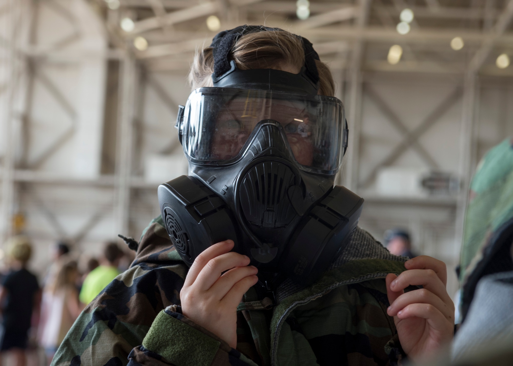 Mackenzie Buss, daughter of U.S. Air Force Maj. Mary Buss, an executive officer assigned to the 730th Air Mobility Training Squadron, wears mission-oriented protective posture gear during the Kids Deployment Line, August 2, 2018, at Altus Air Force Base, Okla.