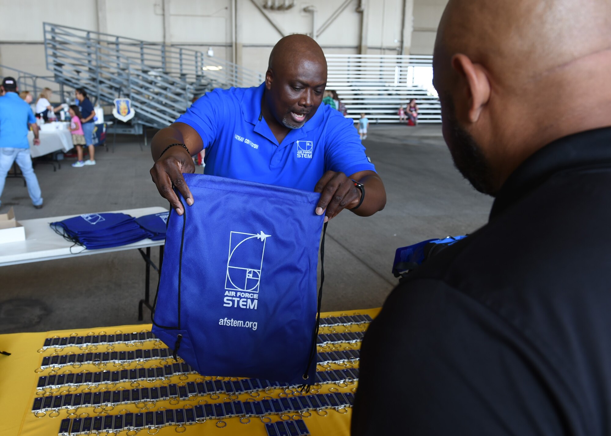 Nathan Covington, a school liaison officer at the Airman and Family Readiness Center, hands out a backpack for preschoolers at the Kids Deployment Line, August 2, 2018, at Altus Air Force Base, Okla.