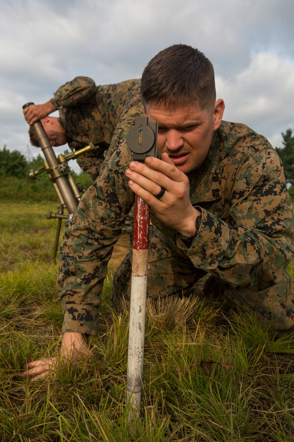 Cpl. Eric Cruser, a mortarman with Lima Company, 3rd Battalion, 25th Marine Regiment, aligns the front and rear aiming stakes with a compass during Exercise Northern Strike at Camp Grayling, Mich., Aug. 7, 2018. Camp Grayling, the largest National Guard center in the country covering 147,000 acres, offers many large artillery, mortar, tank ranges and maneuver courses. (U.S. Marine Corps photos by Cpl. Niles Lee)