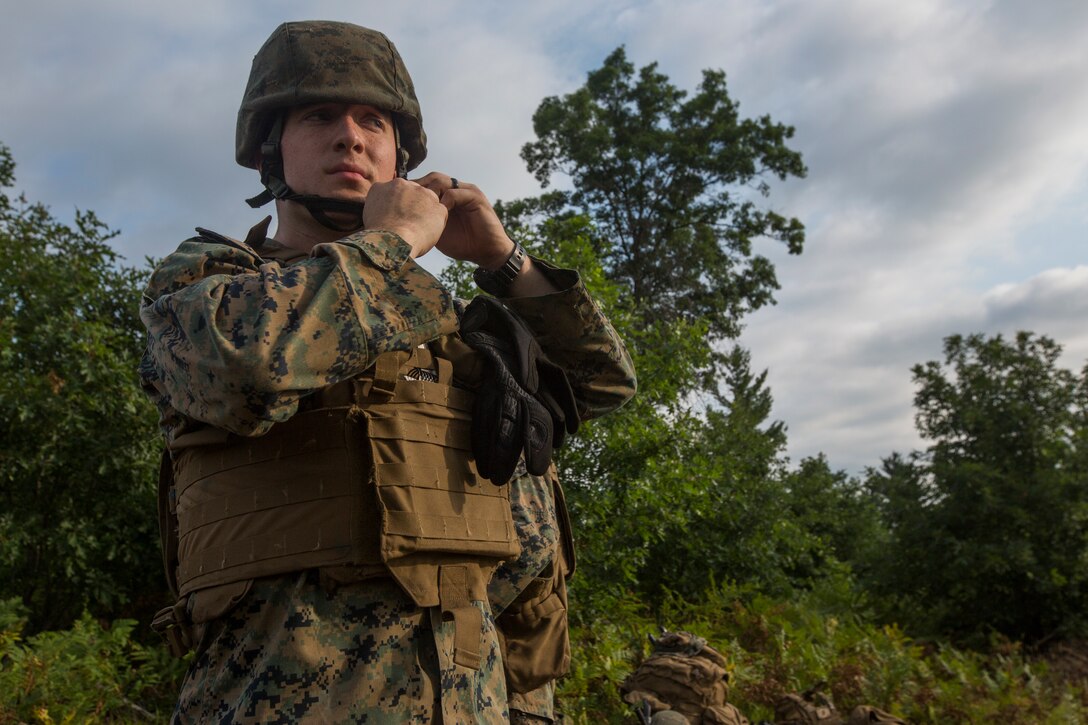 Lance Cpl. Alexander Banik, a mortarman with Lima Company, 3rd Battalion, 25th Marine Regiment, dons his protective equipment before running practice fire missions during Exercise Northern Strike at Camp Grayling, Mich., Aug. 7, 2018.