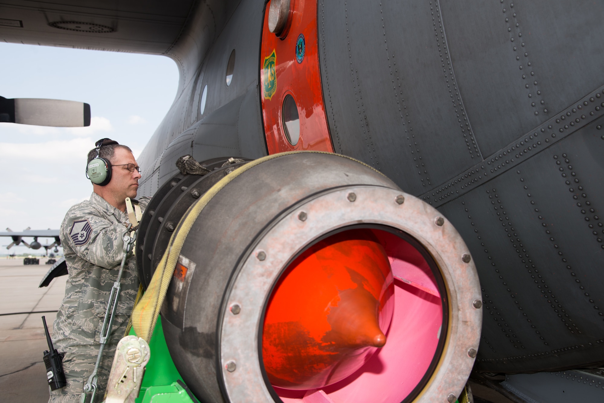 Master Sgt. Jeff Hardsock,302nd Aircraft Maintenance Squadron flight line expediter, inspects the U.S. Department of Agriculture Forest Service’s Modular Airborne Fire Fighting System nozzle attached to an Air Force Reserve Command C-130 Hercules aircraft at Peterson Air Force Base, Colorado, Aug. 6, 2018.