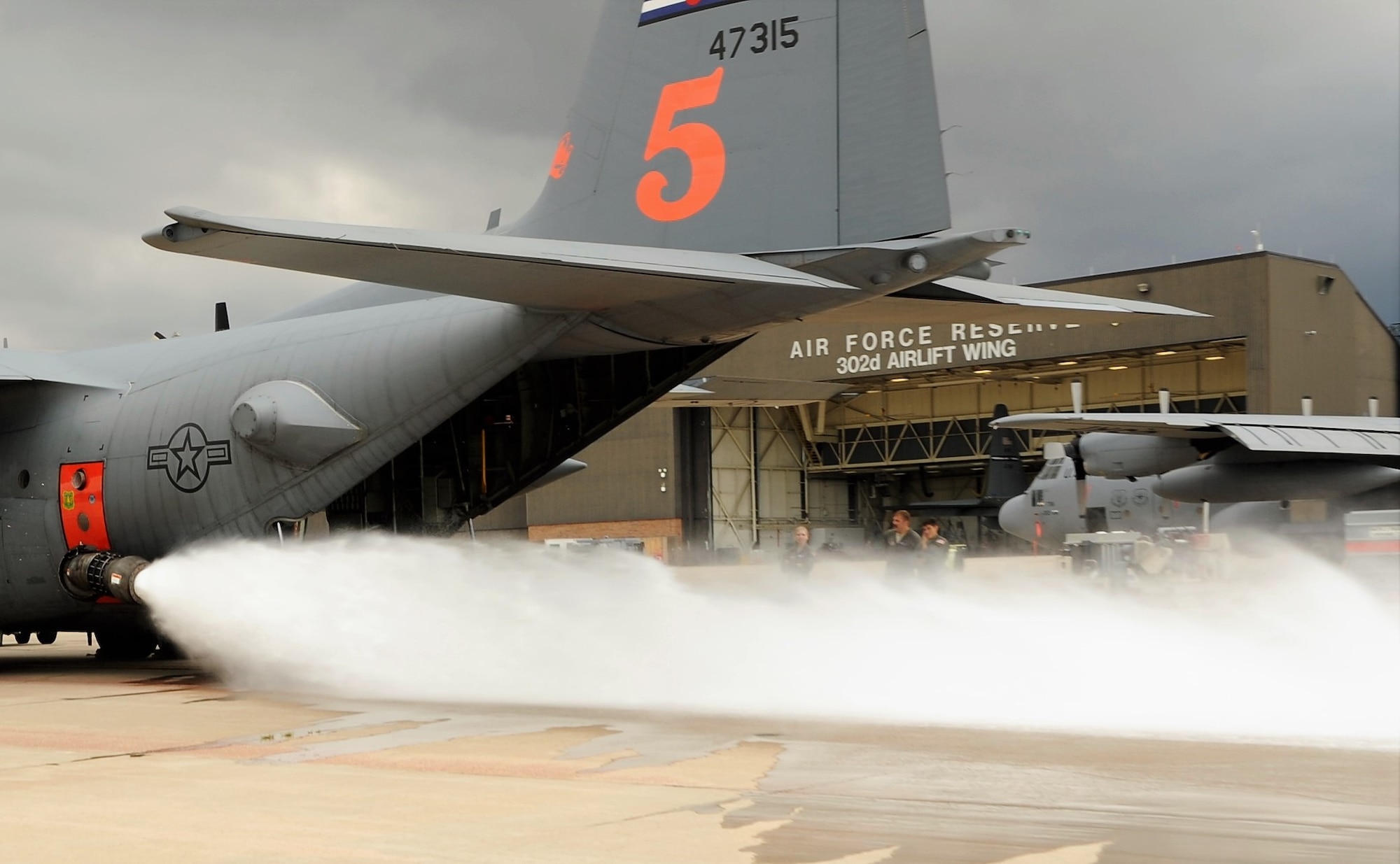 Loadmasters assigned to the 302nd Airlift Wing conduct a wet fire test of the U.S. Department of Agriculture Forest Service’s Modular Airborne Fire Fighting System installed onto one of the Reserve wing’s C-130 Hercules aircraft at Peterson Air Force Base, Aug. 8, 2018.