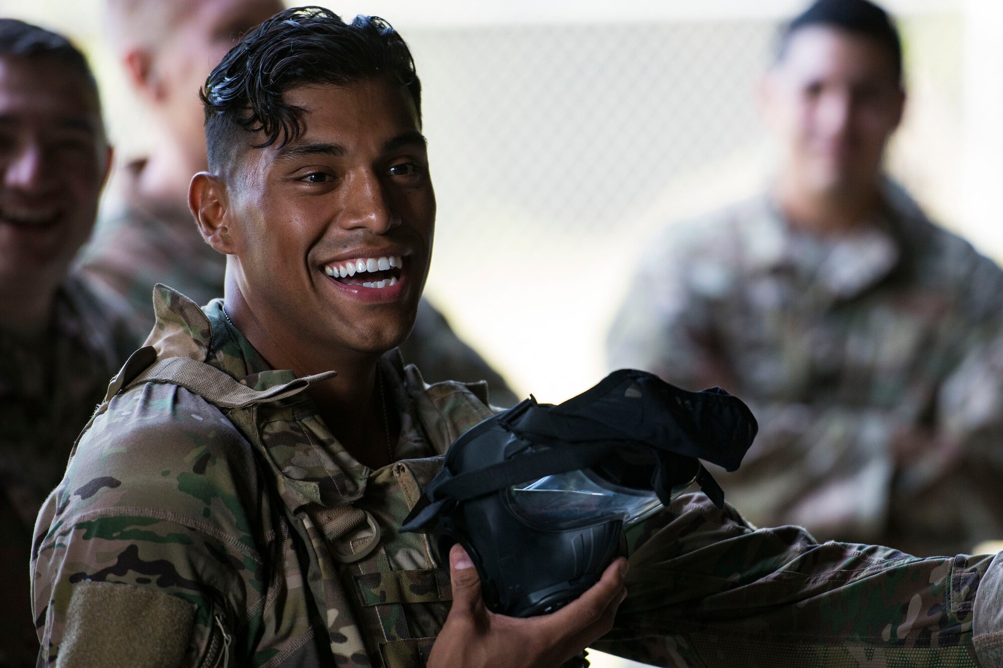 Tech. Sgt. Christopher Zavala, 822d Base Defense Squadron (BDS) squad leader, laughs before donning an M50 gas mask for the shooting competition portion of the Defender Challenge assessment, July 30, 2018, at Moody Air Force Base, Ga. Seven Moody defenders trudged through a gauntlet that tested their capability, lethality and readiness. Ultimately, only Senior Airman Jeffrey Lewis, 822d BDS fireteam leader, had the scores, determination and perseverance to advance to the next level for a chance to represent Air Combat Command during the 2018 Defender Challenge, Sept. 8-14, at Joint Base San Antonio-Camp Bullis, Texas. (U.S. Air Force photo by Airman 1st Class Erick Requadt)