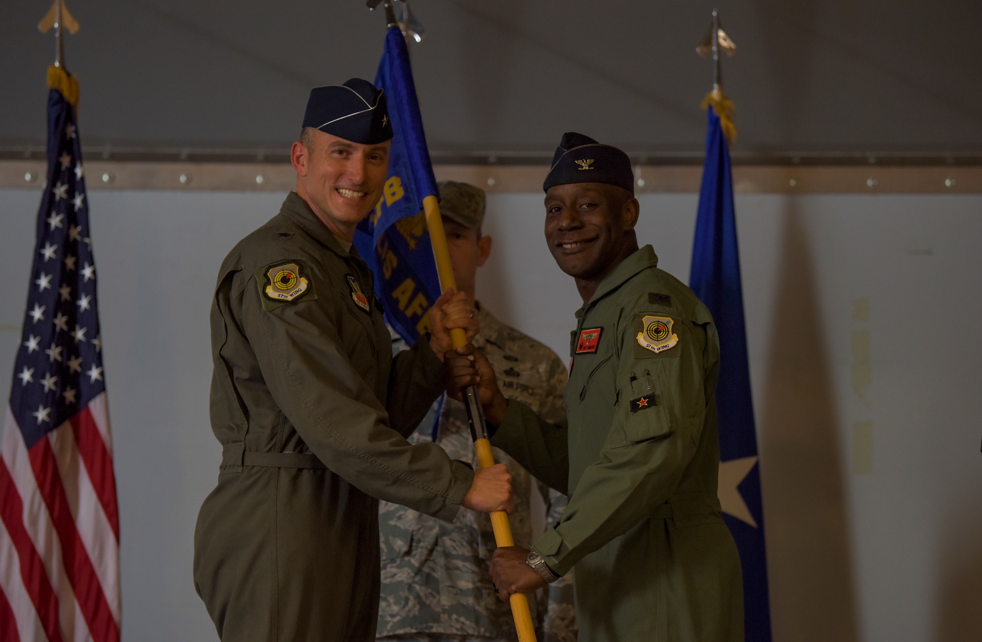 Brig. Gen. Robert Novotny, 57th Wing commander, passes the guidon to Col. Travolis Simmons, 57th Adversary Tactics Group incoming commander, during a change of command ceremony at Nellis Air Force Base, Nevada, Aug. 3, 2018. The 57th ATG is made up of seven squadrons, including three geographically separated units. (U.S. Air Force photo by Airman 1st Class Andrew D. Sarver)