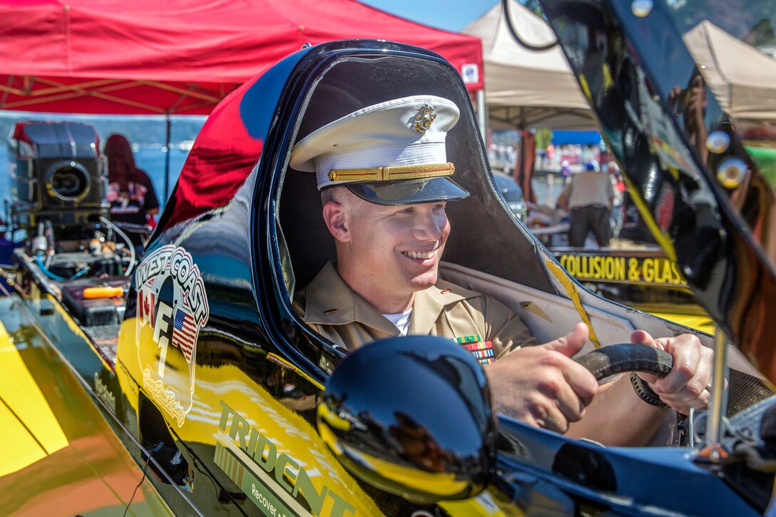 A Marine sits in a vehicle.