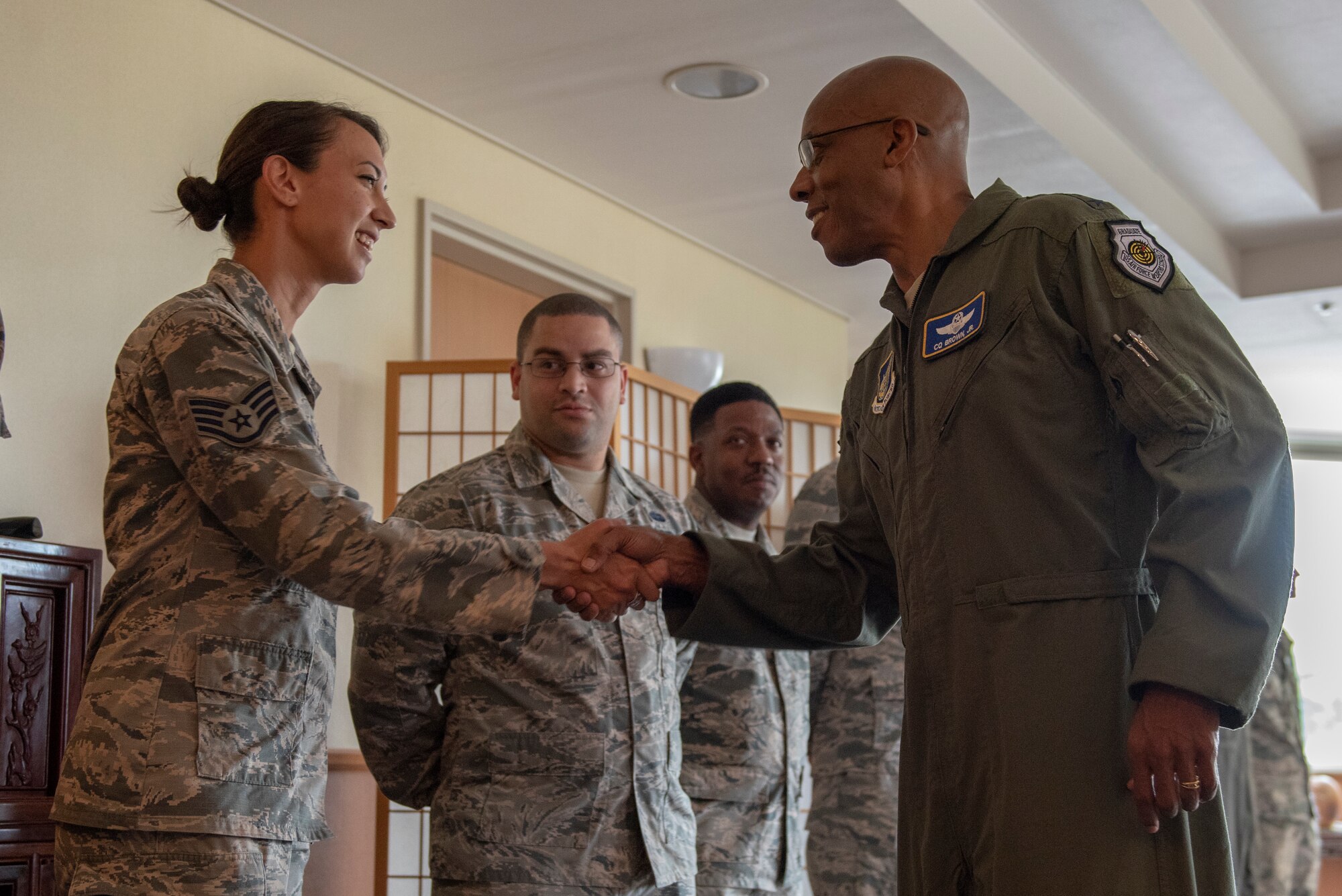 Gen. CQ Brown, Jr., Pacific Air Forces commander, presents a coin to Staff Sgt. Erika Wallfred   374th Communications Squadron, cyber systems defense supervisor, at Yokota Air Base, Japan, Aug. 8, 2018. This was Brown’s first trip to the region since taking command on July 26, 2018.