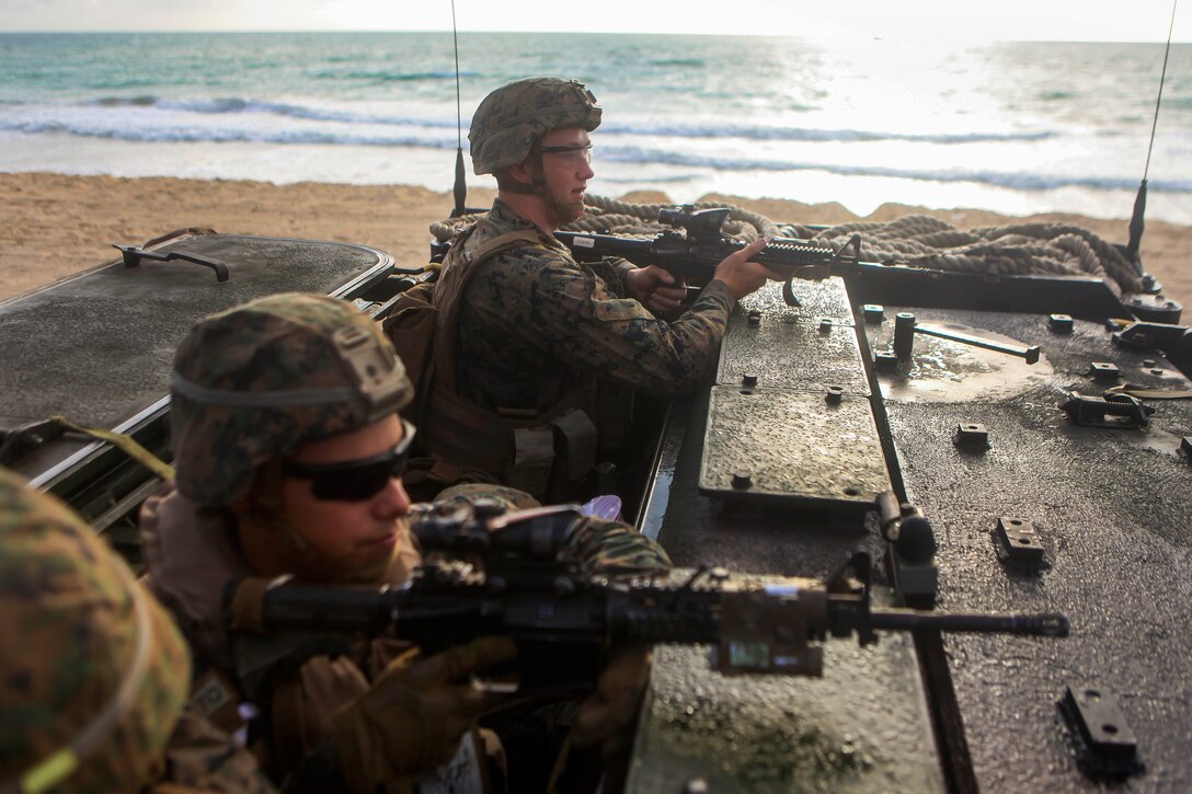 Marines provide security from an assault amphibious vehicle.