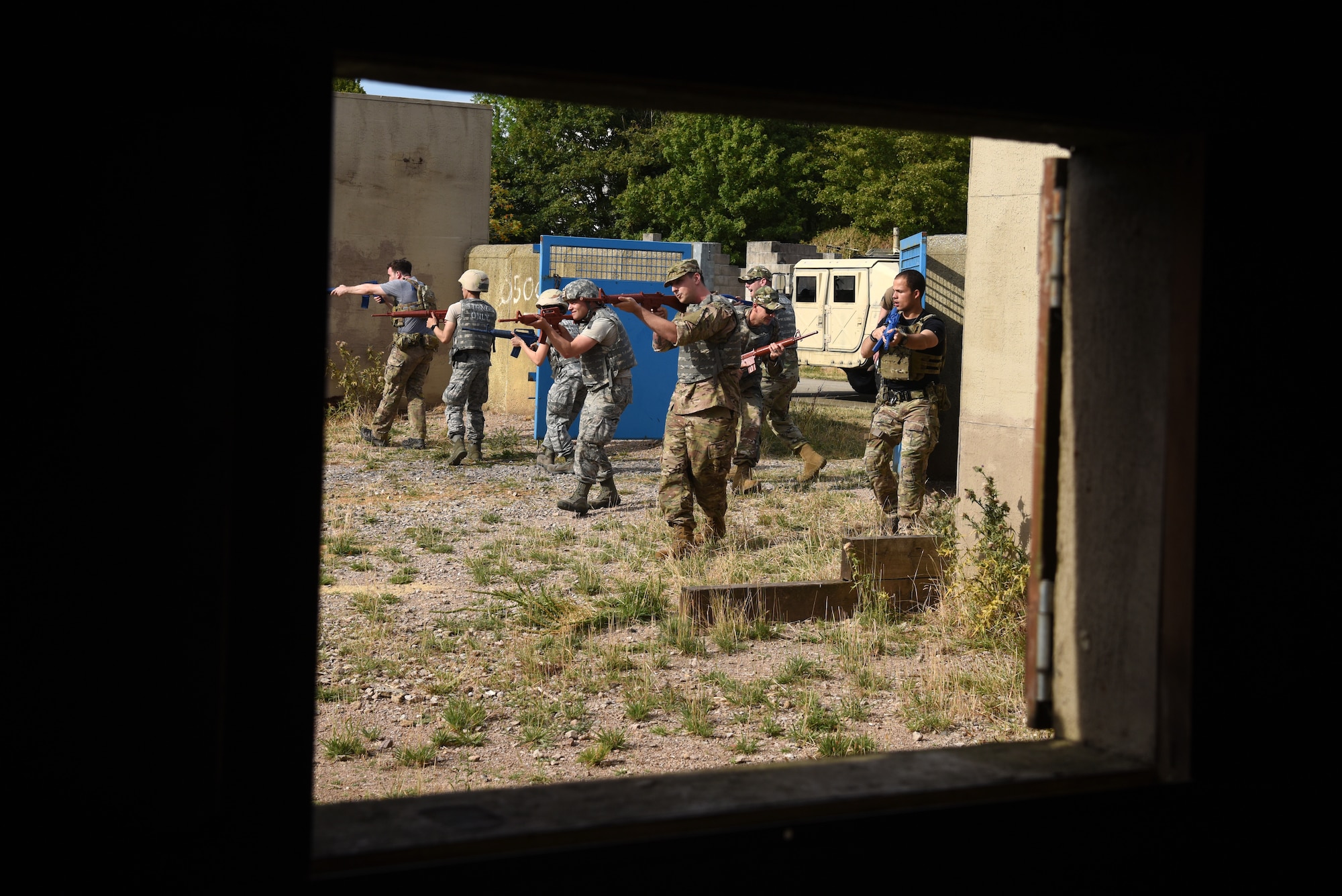 Ground transportation specialists assigned to the 48th Logistics Readiness Squadron and 100th Logistics Readiness Squadron clear a courtyard during a Military Operations in Urban Terrain (MOUT) training course at the Stanford Training Area, Suffolk, England, Aug. 4, 2018. MOUT training teaches Airmen skills in vehicle disembarking under hostile enemy fire, room clearing techniques, overwatch, and team small unit movements. (U.S. Air Force photo/ Airman 1st Class John A. Crawford)