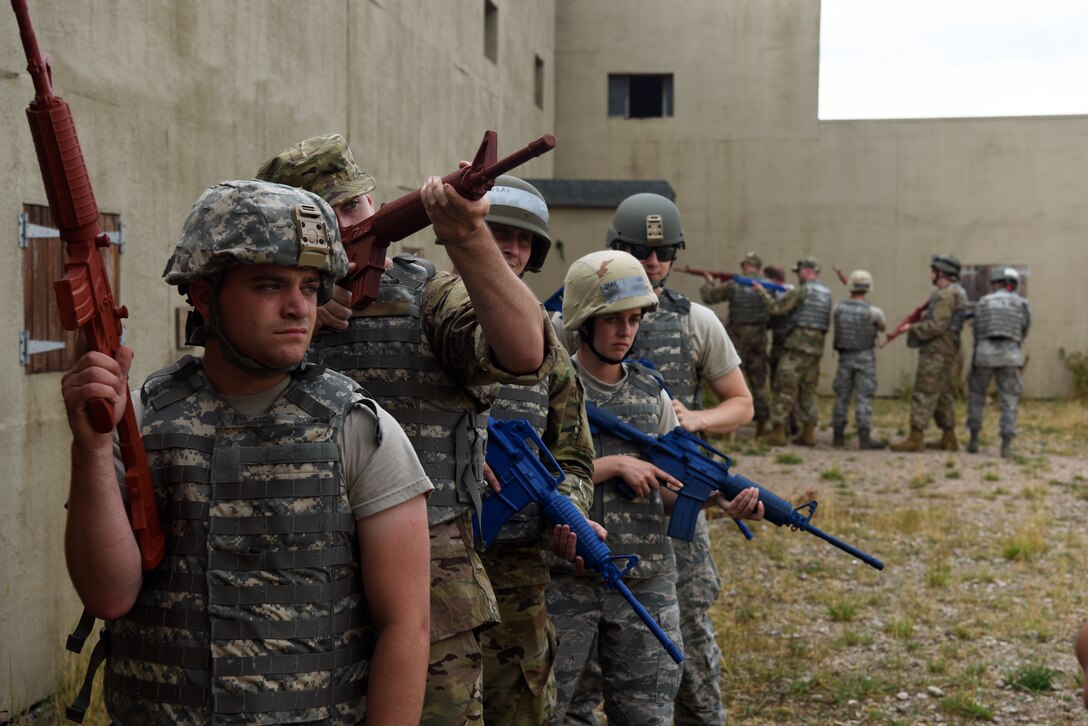 Ground transportation specialists assigned to the 48th Logistics Readiness Squadron and 100th Logistics Readiness Squadron prepare to enter a structure during a Military Operations in Urban Terrain (MOUT) training course at the Stanford Training Area, Suffolk, England, Aug. 4, 2018. This is the first year that ground transportation specialist from Royal Air Force Lakenheath and RAF Mildenhall partnered together for Contingency Operational Readiness Training. (U.S. Air Force photo/ Airman 1st Class John A. Crawford)