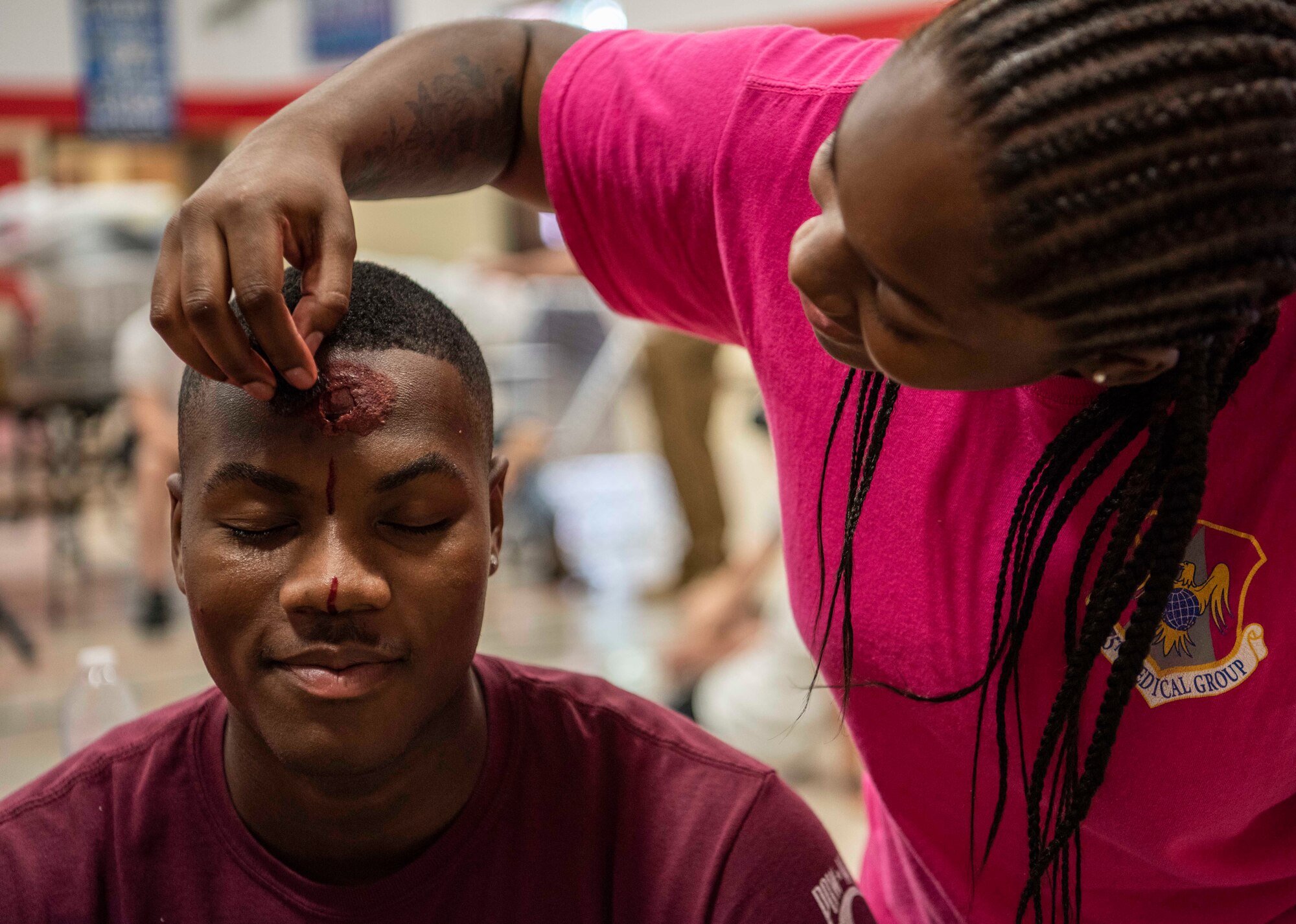 An Airman from the 375th Medical Group moulage team, applies fake blood to a volunteer during an active shooter exercise July 24, 2018, at Whiteside Elementary School, Belleville, Illinois.